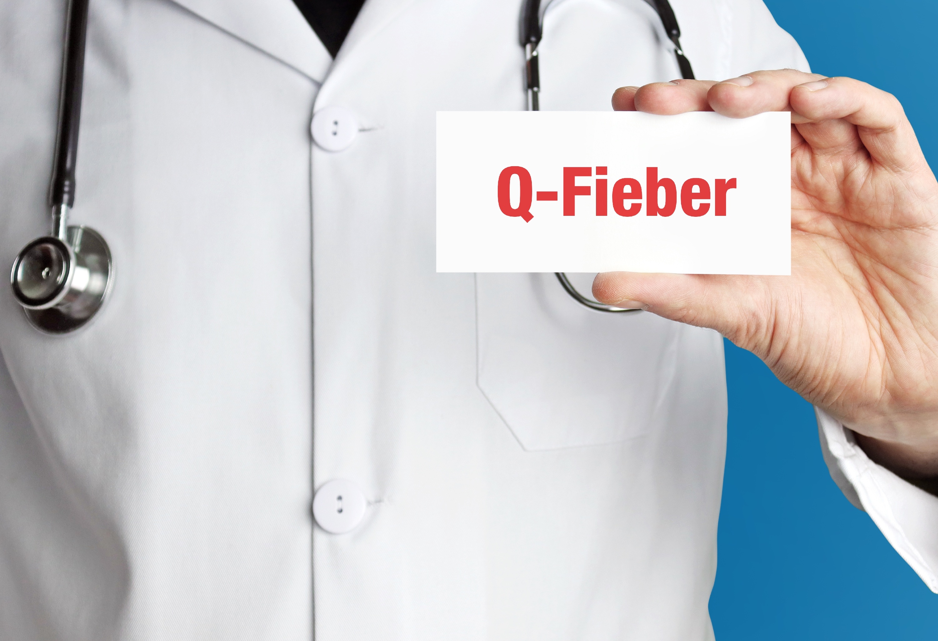Arzt hält Schild mit Aufschrift Q-Fieber