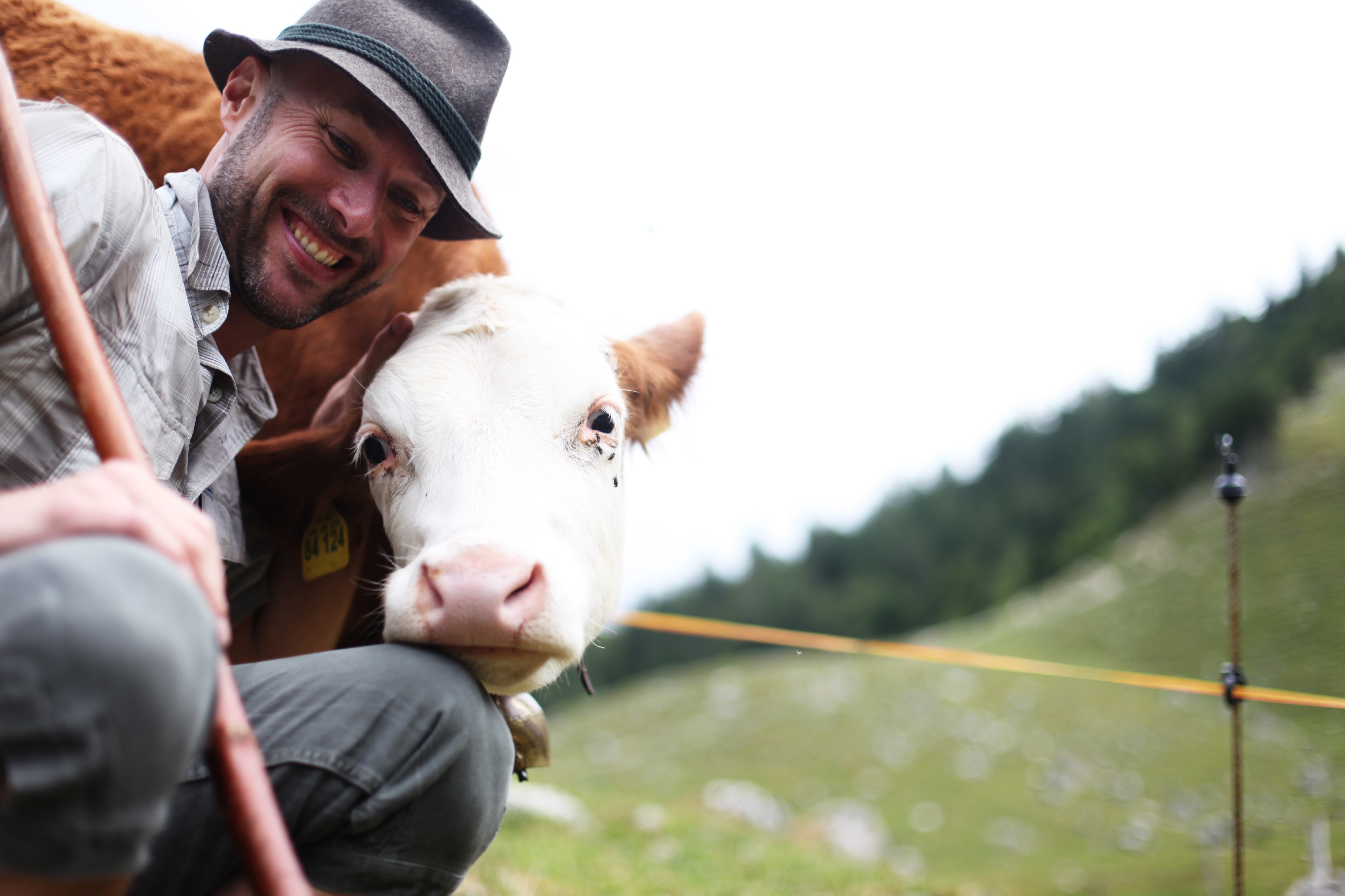 Landwirt und Kuh schauen glücklich in die Kamera